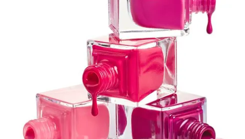 glass polish containers on their sides dripping shades of pink and purple